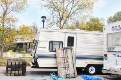 Photo by Scooter MacMillan. A couple of the RVs providing shelter to unhoused people are parked with the train station in the background.